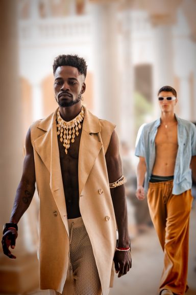 Modelo masculino con collar y chaqueta sin mangas, seguido por otro modelo en ropa casual.